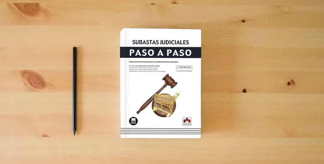 The book Subastas judiciales. Paso a paso: Guía pormenorizada del procedimiento de subastas: 1} is on the table