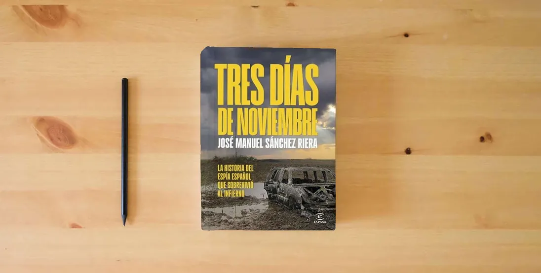 The book Tres días de noviembre: La historia del espía español que sobrevivió al infierno (NO FICCIÓN)} is on the table
